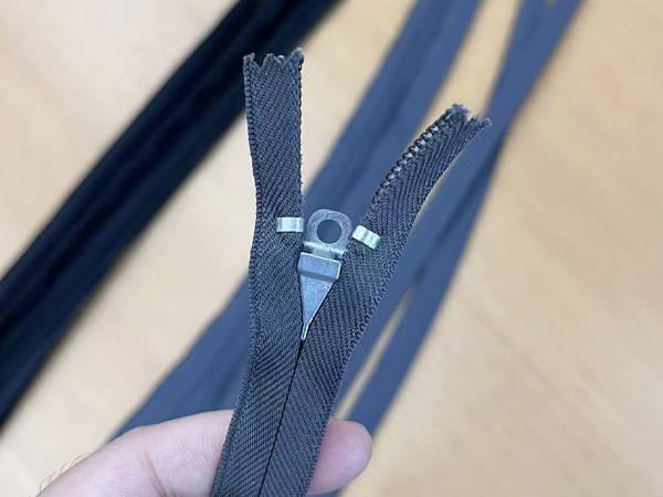 Close-up of a gray car seat zipper with a concealed design, developed by RHF Zipper for automotive manufacturers, showcasing durability and smooth functionality