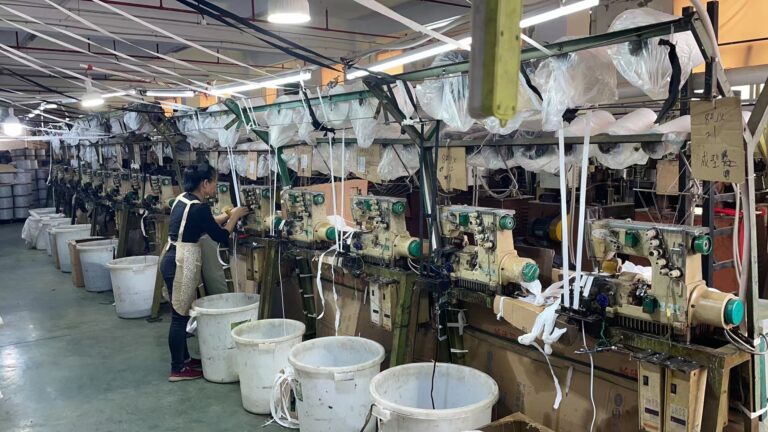Worker operating zipper manufacturing equipment at RHF Zipper