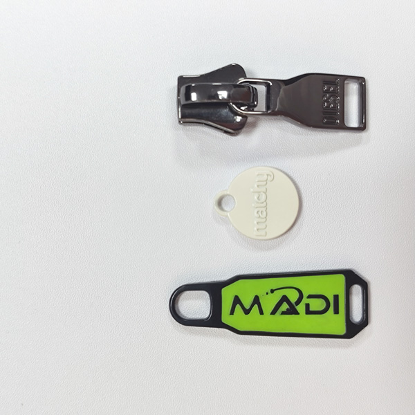 Logo Processes for Custom Metal Zipper Pullers custom metal zipper puller with logo debossed embossed paint filled and laser engraved finishes