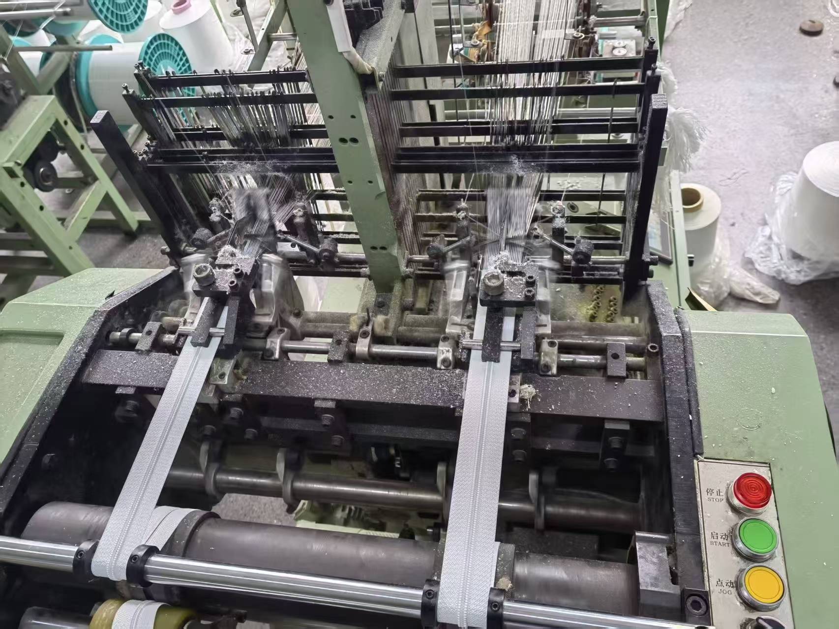 Close-up view of precision separating zippers being manufactured on an automated production machine.